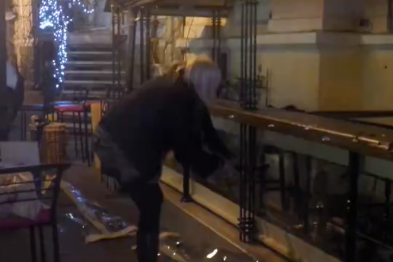 В центре Одессы обозленная хозяйка кафе начала на глазах у полиции рубать лестницу топором