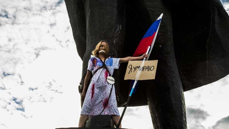 "Я умираю!" - девушка в Новосибирске приковала себя цепями к памятнику, олицетворяя Россию, - кадры