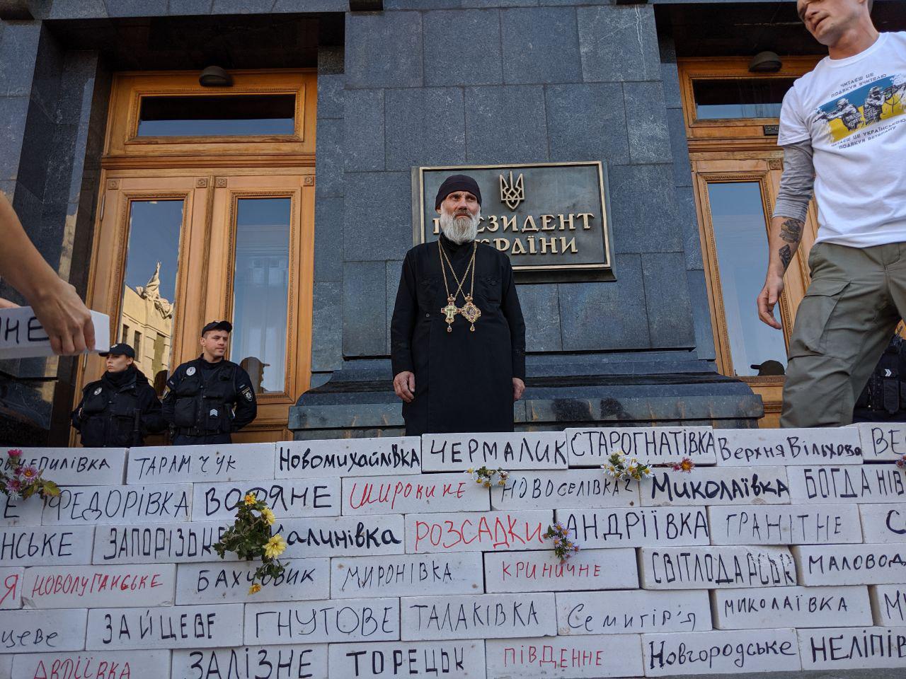 Митингующие у Офиса Зеленского строят стену в "крови" с названиями сел на линии фронта - кадры