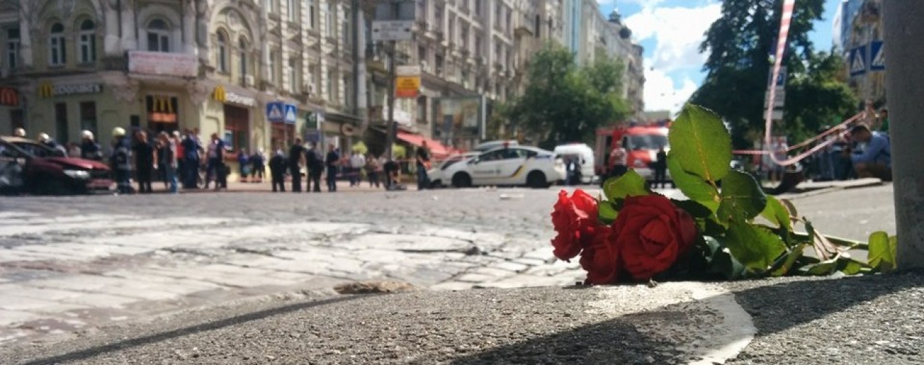 Место, где погиб Павел Шеремет, утопает в цветах. Пожарные убирают обломки взорванной машины 