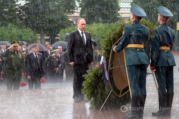 ​"Даже нимб не помогает - три волосины, зачесанные на лысину, все равно промокли", - соцсети высмеяли "мокрые" фото Путина во время церемонии возложения цветов - кадры